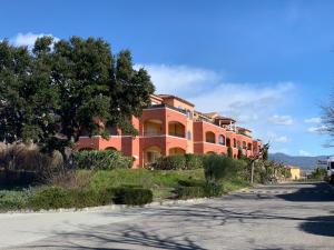 un grand bâtiment orange sur le côté d'une route dans l'établissement Appartement 12 - Golf de Roquebrune - Vue mer imprenable !, à Roquebrune-sur Argens