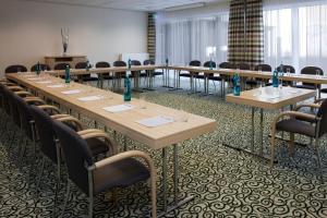 einen Konferenzraum mit langen Tischen und Stühlen in der Unterkunft Holiday Inn Express Gütersloh, an IHG Hotel in Gütersloh