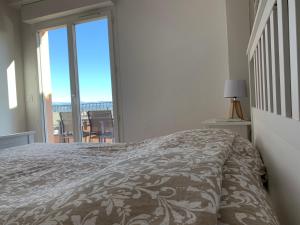 a bedroom with a bed and a view of a balcony at Appartement 12 - Golf de Roquebrune - Vue mer imprenable ! in Roquebrune-sur-Argens
