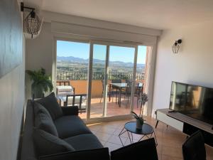 a living room with a couch and a television at Appartement 12 - Golf de Roquebrune - Vue mer imprenable ! in Roquebrune-sur-Argens