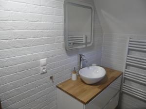 a white bathroom with a sink and a mirror at Chata Habovka in Habovka