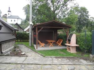 einen Pavillon mit Stühlen, einem Tisch und einem Grill in der Unterkunft Chata Habovka in Habovka