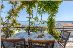 a table with a plate of food on a balcony at Knezovicapartments in Živogošće
