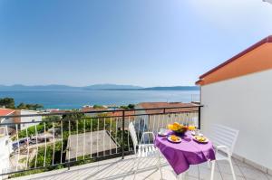 a balcony with a table with a purple table cloth at Knezovicapartments in Živogošće