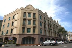 duży budynek z samochodami zaparkowanymi przed nim w obiekcie Hotel Seri Costa w Malakce