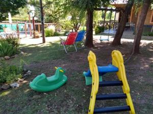 un parque infantil con tobogán y 2 equipos de juego en Casa La Serena en Los Reartes