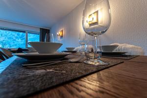 uma mesa de jantar com copos e pratos em Steinfeldstudio in Rottach Egern em Rottach-Egern