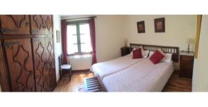 貝納斯克的住宿－Casa el Roso，一间卧室配有一张带两个红色枕头的床