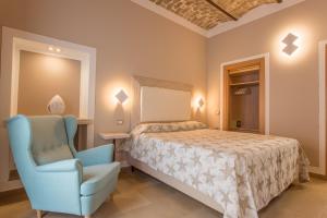 a hotel room with a bed, chair, table and lamps at Residenza Sveva in Termoli