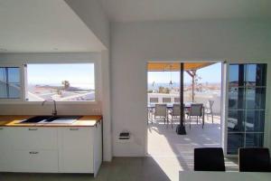 a kitchen and dining room with a view of a patio at Casa Vista al Mar in Abades