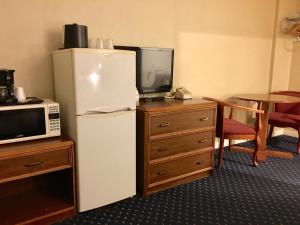 a room with a refrigerator and a microwave and a table at Scottish Inns Fayetteville in Fayetteville