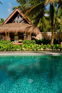 a beach with palm trees and palm trees at Las Palmas Villas and Casitas Siargao in General Luna