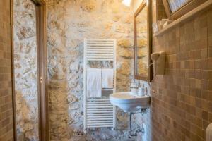 baño con lavabo y pared de piedra en Cubanito Bailon, en Ascoli Piceno