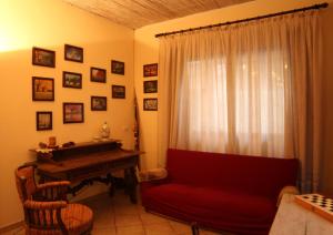 ein Wohnzimmer mit einem roten Sofa und einem Klavier in der Unterkunft L'Angoletto in Trecastagni