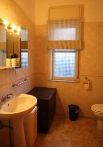 La salle de bains est pourvue d'un lavabo, de toilettes et d'une fenêtre. dans l'établissement L'Angoletto, à Trecastagni