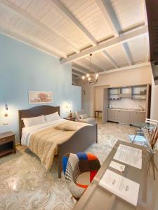 ein Schlafzimmer mit einem großen Bett und einem Tisch in der Unterkunft Case Vacanze Al Duomo in Licata