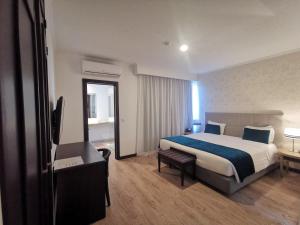 a hotel room with a bed and a flat screen tv at Santa Cruz Village Hotel in Santa Cruz