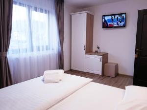 a bedroom with a white bed and a window at Pensiunea Aida in Gura Humorului