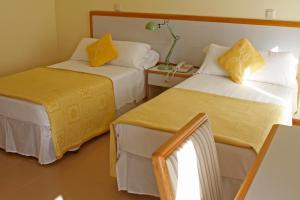 a hotel room with two beds with yellow pillows at Hotel Playa de Merón in San Vicente de la Barquera