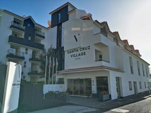 a building with a sign that reads santa cruz village at Santa Cruz Village Hotel in Santa Cruz