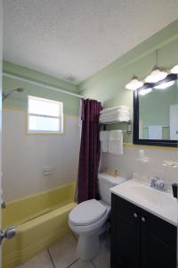 a bathroom with a toilet and a sink and a mirror at Sunshine Inn & Suites Venice, Florida in Venice