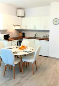 a kitchen with a white table and chairs and a kitchen with white cabinets at MNG-Apart Mareverde Costa Adeje- Las Americas in Adeje