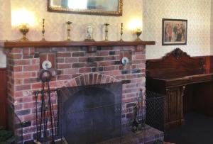 a fire place with a stone fireplace and a brick wall at Leviathan Hotel in Dunedin