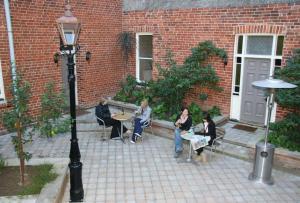 un grupo de personas sentadas en mesas en un patio en Leviathan Hotel, en Dunedin