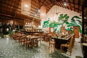 a restaurant with tables, chairs, and tables in it at Las Palmas Villas and Casitas Siargao in General Luna