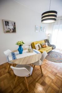 een woonkamer met een tafel en stoelen en een bank bij Oporto Choose Happiness in Porto