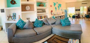 uma sala de estar com um sofá cinzento com almofadas azuis em Hostal Bucerias em Bucerías