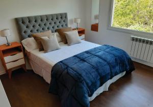 1 dormitorio con 1 cama grande con manta azul en Departamento en el centro de Bariloche tb en San Carlos de Bariloche