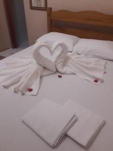 een wit bed met 2 zwanen gemaakt van handdoeken bij Food park Guaramiranga in Guaramiranga