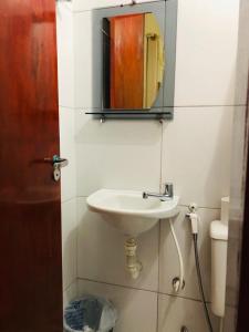 een badkamer met een wastafel en een spiegel aan de muur bij Food park Guaramiranga in Guaramiranga