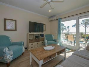 ein Wohnzimmer mit einem Sofa, einem Tisch und einem TV in der Unterkunft Direct Oceanfront Private Villa Overlooking Pool/Beach - South Forest Beach - Right next to Coligny Plaza in Hilton Head Island