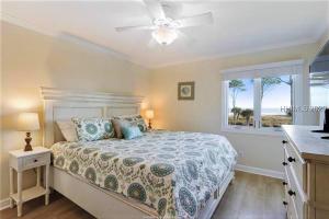 a bedroom with a bed with a ceiling fan and a window at Direct Oceanfront Private Villa Overlooking Pool/Beach - South Forest Beach - Right next to Coligny Plaza in Hilton Head Island +38 photos