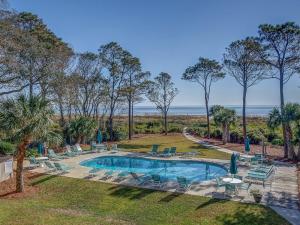 una piscina al aire libre con sillas y una playa en Direct Oceanfront Private Villa Overlooking Pool/Beach - South Forest Beach - Right next to Coligny Plaza en Hilton Head Island