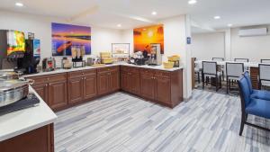 a kitchen with wooden cabinets and tables and chairs at Best Western Atlanta-Marietta Ballpark Hotel in Atlanta