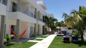 卡姆布庫的住宿－KiteBar Hotel，享有带草和棕榈树的建筑的外部景色