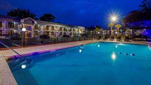 una piscina por la noche con un hotel en Best Western Central Inn en Savannah