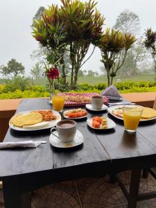 a table with plates of food and cups of coffee at Acantos Hotel Campestre in Támesis