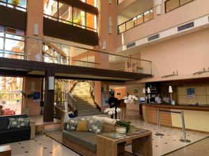 a lobby with a couch and stairs in a building at Jurerê Beach Village - Flat na Praia in Florianópolis