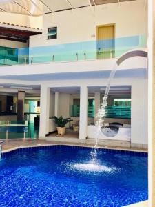 a large swimming pool with a fountain in a building at MIRAGE HOTEL in Porto Seguro