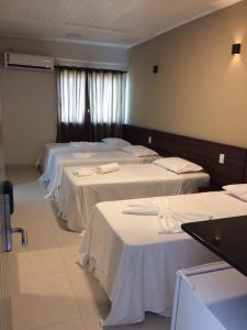 Un grupo de 4 camas en una habitación en MIRAGE HOTEL, en Porto Seguro
