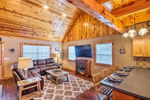 ein Wohnzimmer mit einem Sofa und einem Tisch in der Unterkunft Modern Cabin with Grill Near Golf and Bass Fishing! in Frogue