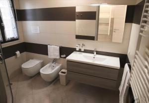 La salle de bains est pourvue d'un lavabo et de toilettes. dans l'établissement LE PITTURE casa di campagna, à Filiano
