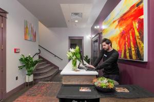 a man standing at a desk with a laptop at The Dundee - A Trace Hotel in Dundee