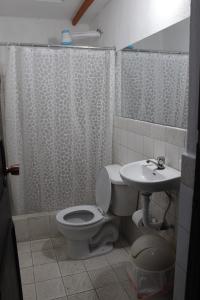 a bathroom with a toilet and a sink at Habitaciones Eco-Terrazas in Guatemala