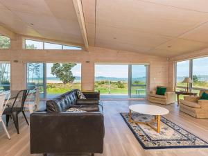 a living room with a couch and a table at Beachfront Escape - Snells Beach Holiday Home in Snells Beach