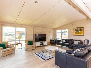 a living room with a couch and a tv at Beachfront Escape - Snells Beach Holiday Home in Snells Beach